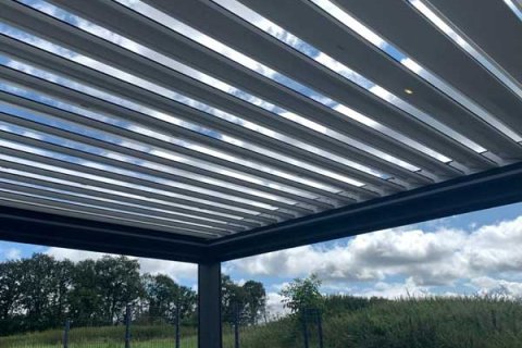 Détail montrant les lamelles ouvertes de la pergola autonome avec toit aux lamelles