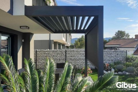 Pergola de Gibus sur mur avec lamelles réglables et zip-screen