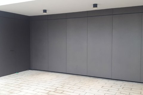 Découpe du bardage en tôle de la porte de garage Découpe de la porte de garage avec bardage en tôle anthracite