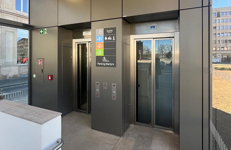 Treppenhaus vom Parking Martyrs mit Blick auf die beiden Aufzüge. Die Wandverkleidung ist mit dem POHL Europanel System verkleidet. Die Seitenwände des Raumes sind verglast.