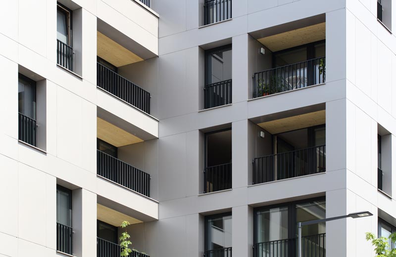 Vue en coupe d'un angle d'un immeuble résidentiel avec des éléments de façade clairs en aluminium (système de façade POHL-EUROPLATE). Chaque appartement dispose d'une loggia avec des balustrades de couleur anthracite.