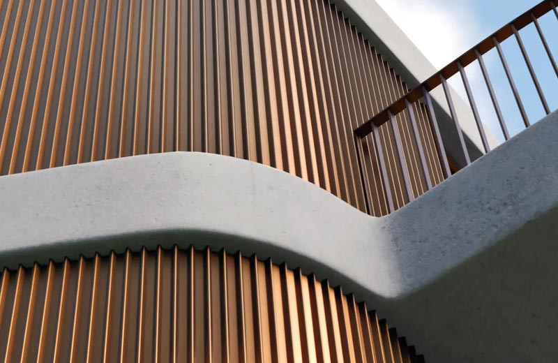 Ausschnitt einer geschwungenen Fassade im Kupferton, die mit dem Fassadensystem Linarte ausgeführt ist. Im rechten Bereich ist ein Balkon mit Geländer angeschnitten zu sehen.